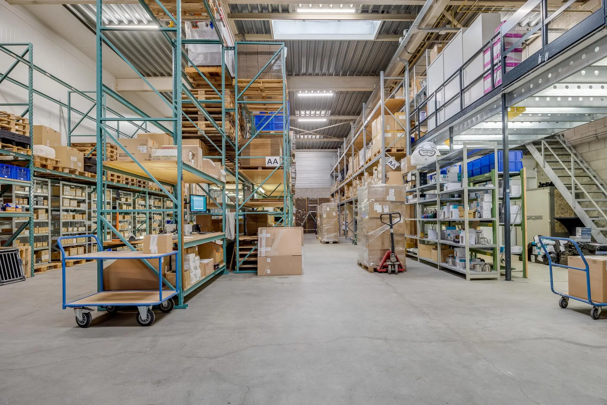 Interieur van een magazijn aan de Savannahweg met stellingen vol dozen, pallets en magazijnkarren.