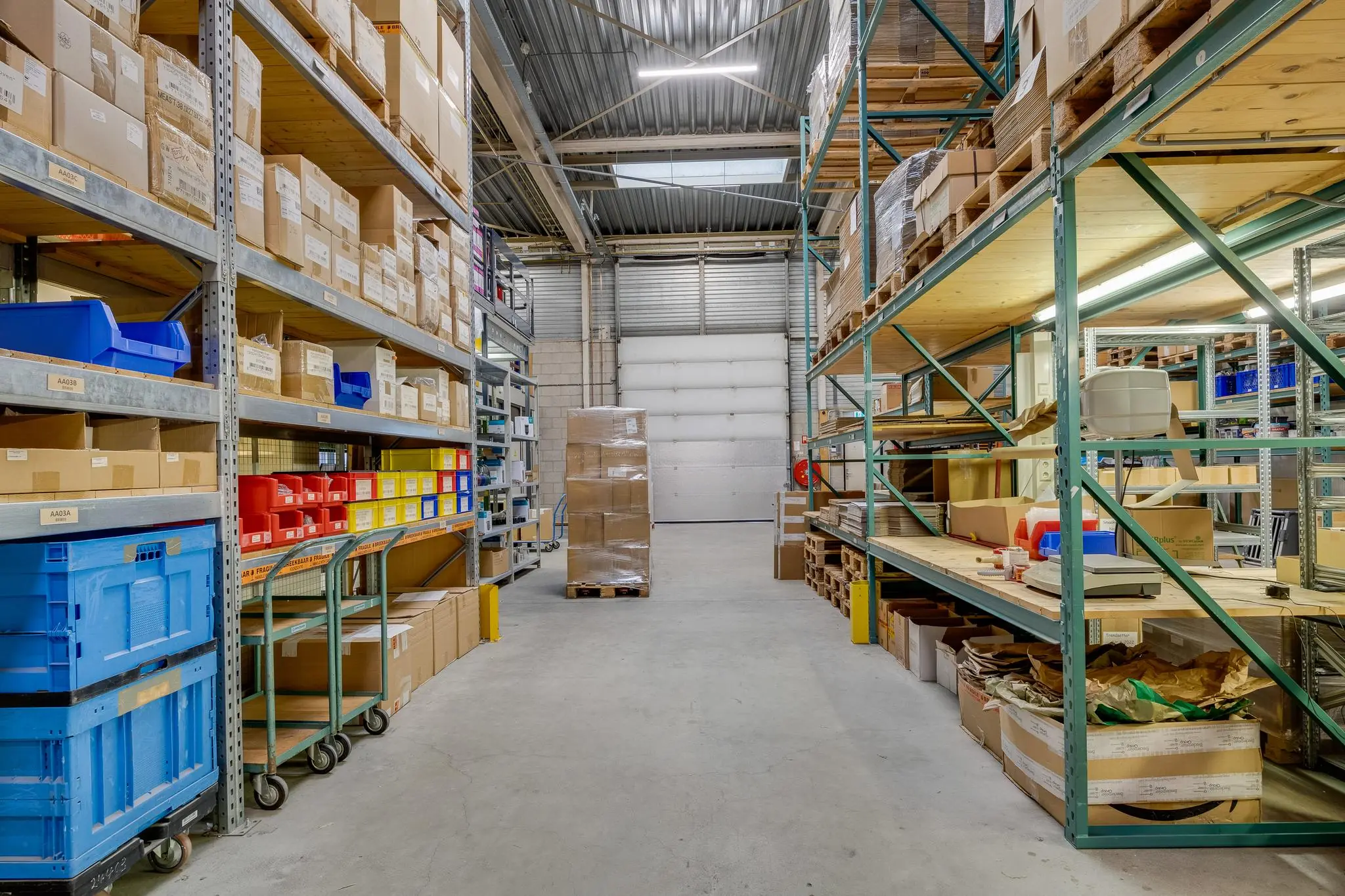 Magazijn aan de Savannahweg met hoge stellingen vol dozen, kunststof bakken en verpakte palletlading.