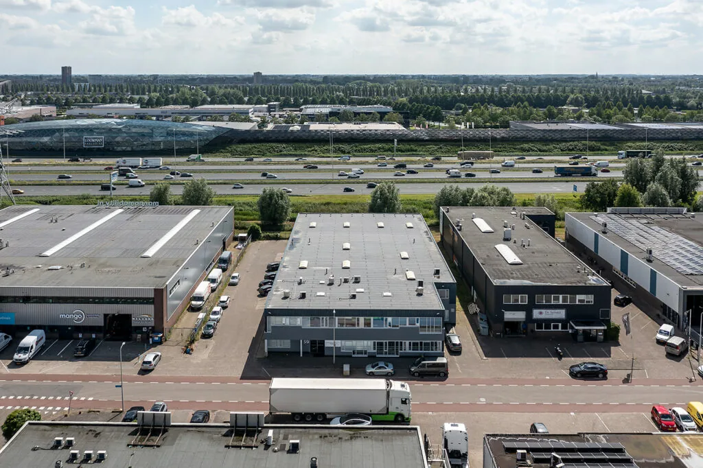 Luchtfoto van een bedrijventerrein aan de Savannahweg in Utrecht met zicht op de snelweg A2 en omliggende gebouwen.