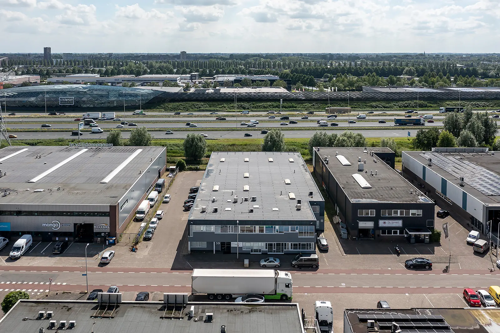 Luchtfoto van een bedrijventerrein aan de Savannahweg in Utrecht met zicht op de snelweg A2 en omliggende gebouwen.