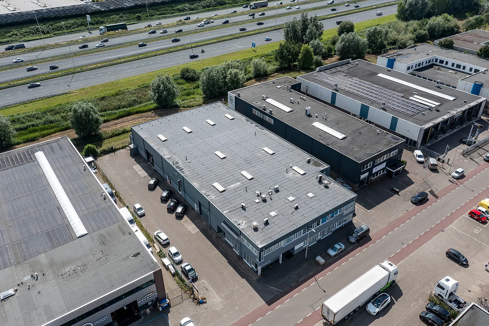 Luchtfoto van bedrijfspanden aan de Savannahweg in Utrecht, gelegen naast een drukke snelweg.