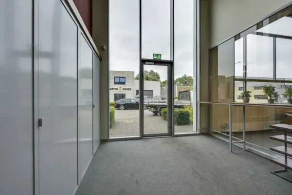 Lichte kantoorruimte met grote glazen ingang en uitzicht op bedrijfsgebouwen aan de Tennesseedreef.