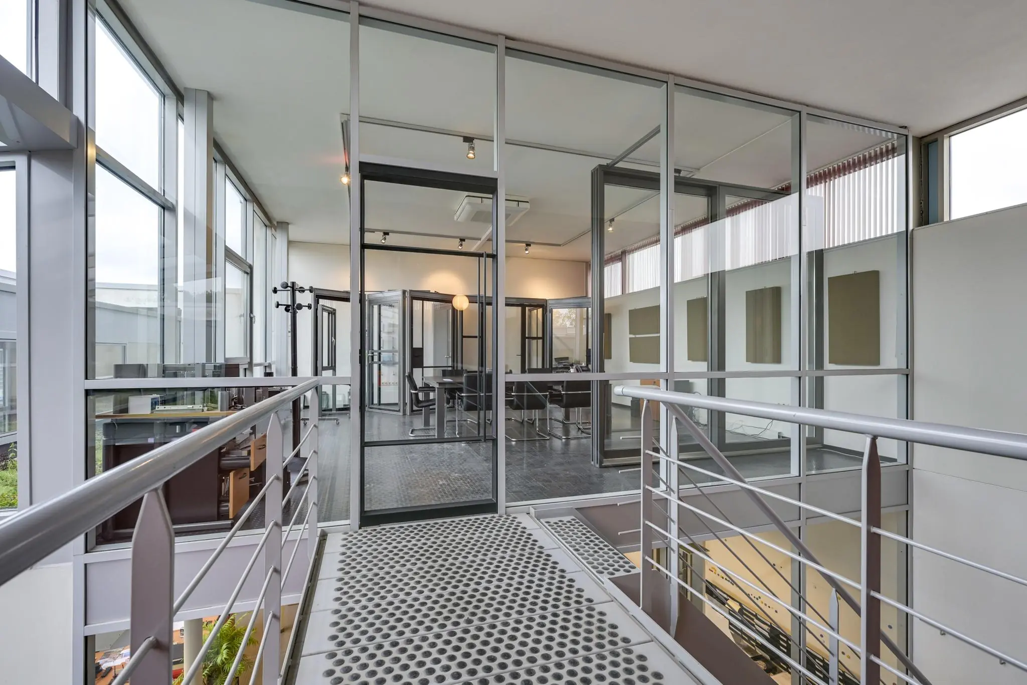 Moderne kantoorruimte aan de Tennesseedreef met glazen wanden en een metalen loopbrug.