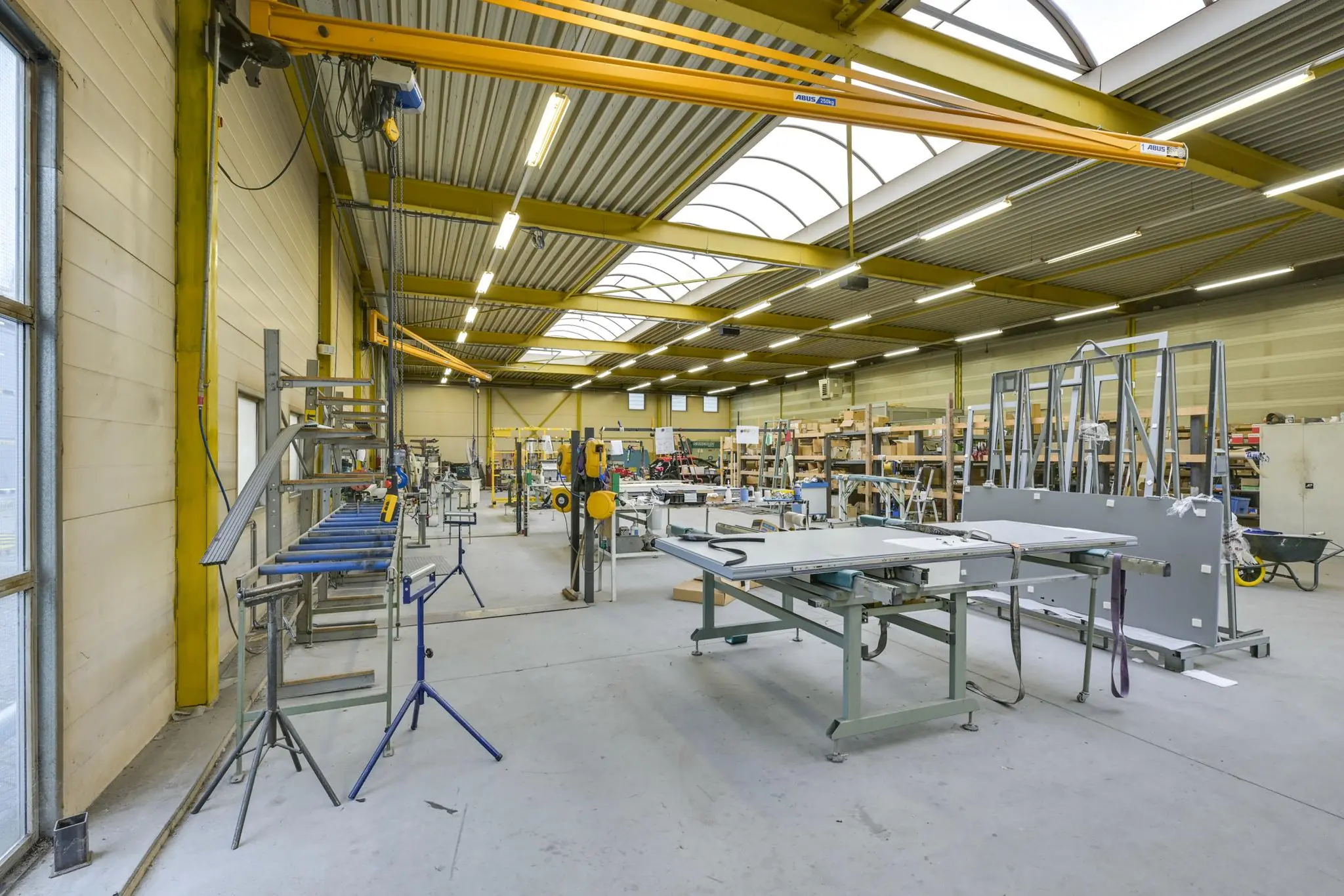 Ruime en nette werkplaats aan de Tennesseedreef met diverse machines, werktafels en gereedschappen.