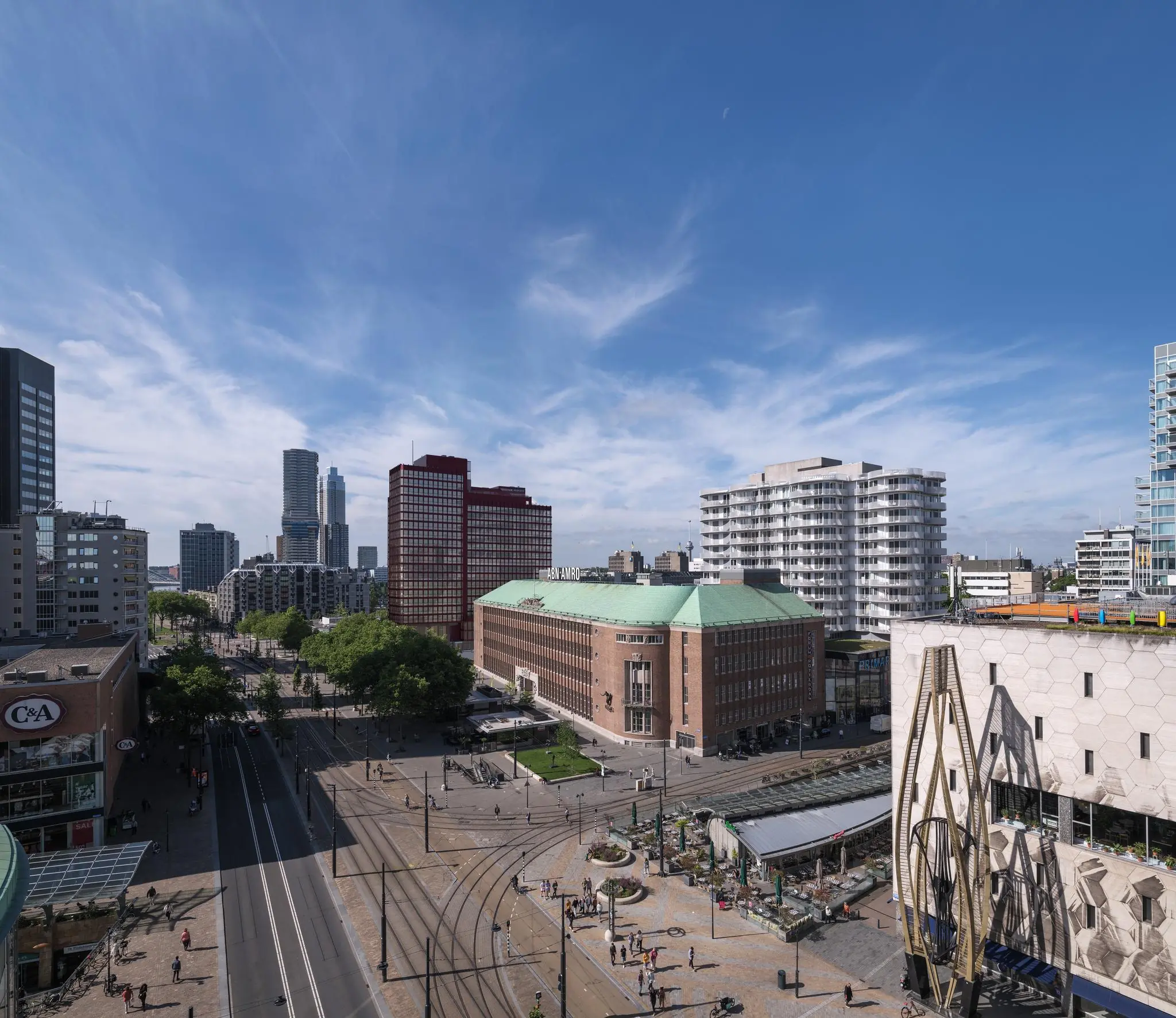 Luchtfoto van de Coolsingel in Rotterdam met het iconische postkantoor, moderne hoogbouw en druk stadsverkeer.