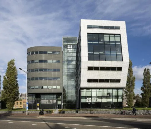 Modern kantoorgebouw van Talpa Network aan het Rietlandpark in Amsterdam met opvallende glazen en witte gevel.