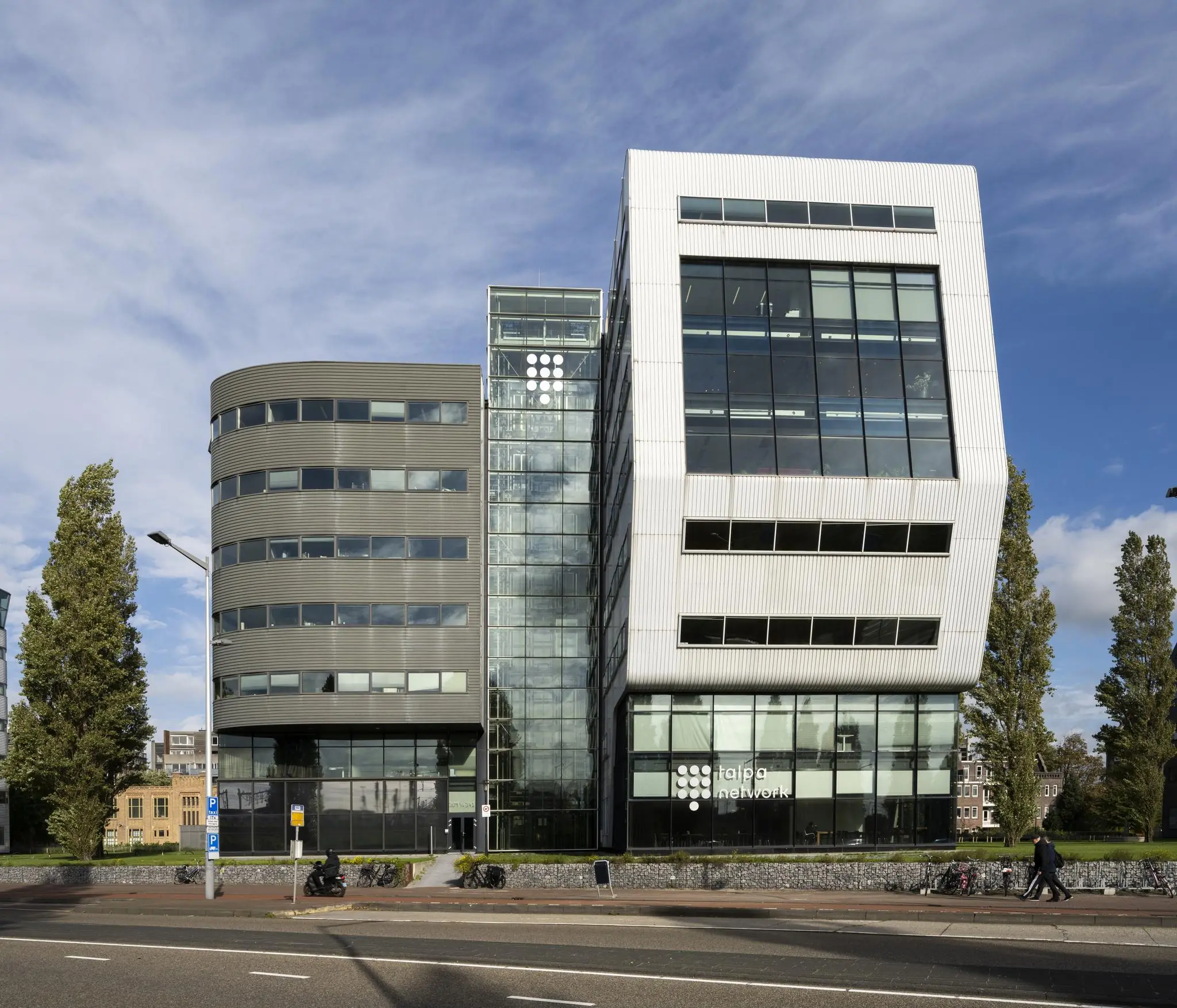 Modern kantoorgebouw van Talpa Network aan het Rietlandpark in Amsterdam met opvallende glazen en witte gevel.