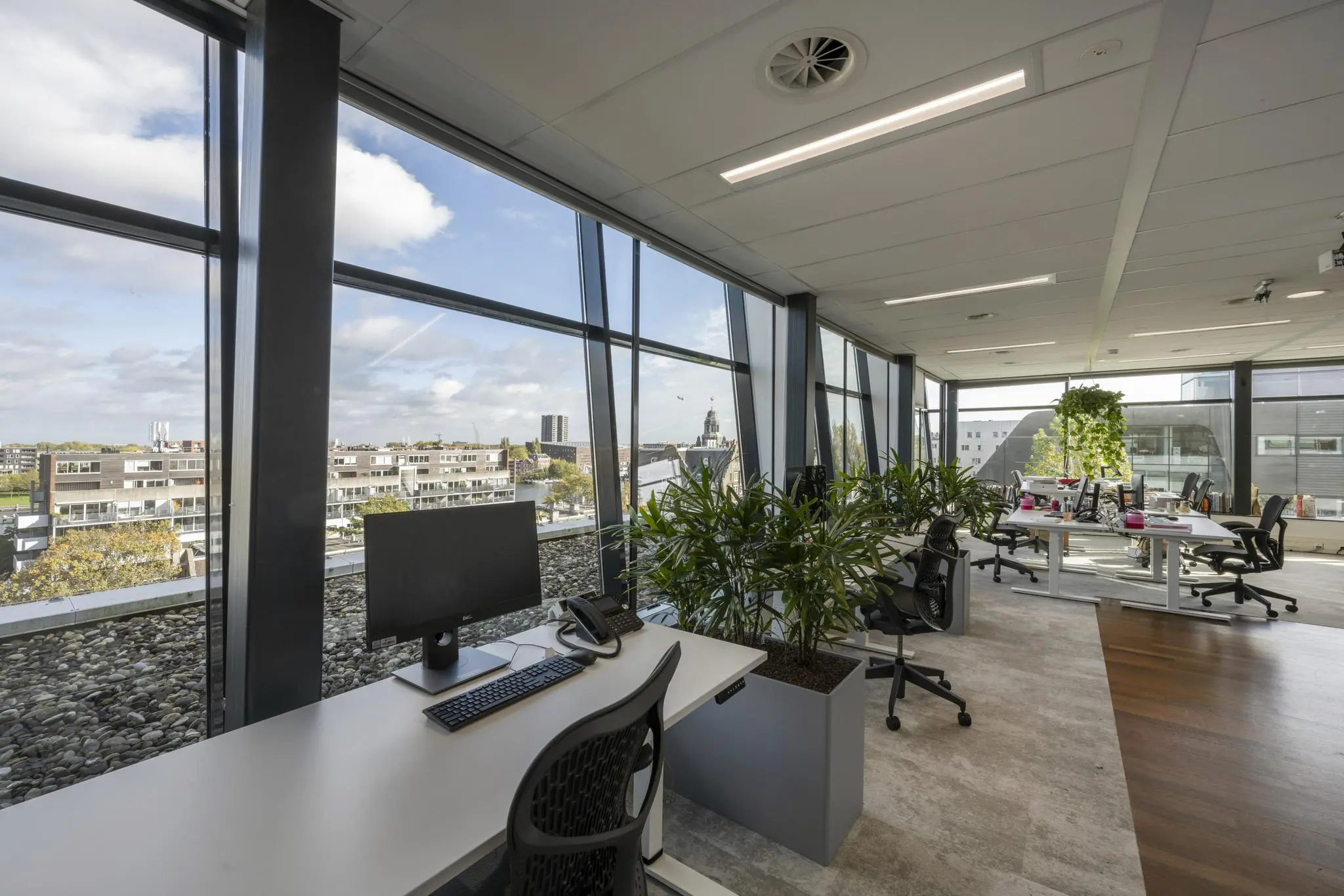 Modern kantoorinterieur in Rietlandpark met ergonomische werkplekken, veel daglicht en uitzicht over de stad.