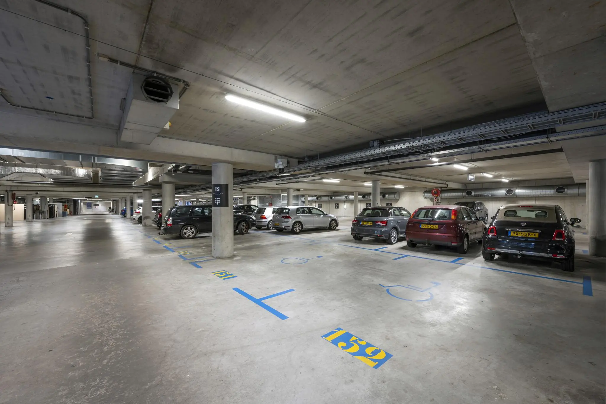 Ondergrondse parkeergarage Rietlandpark met gemarkeerde parkeerplaatsen en geparkeerde auto's.