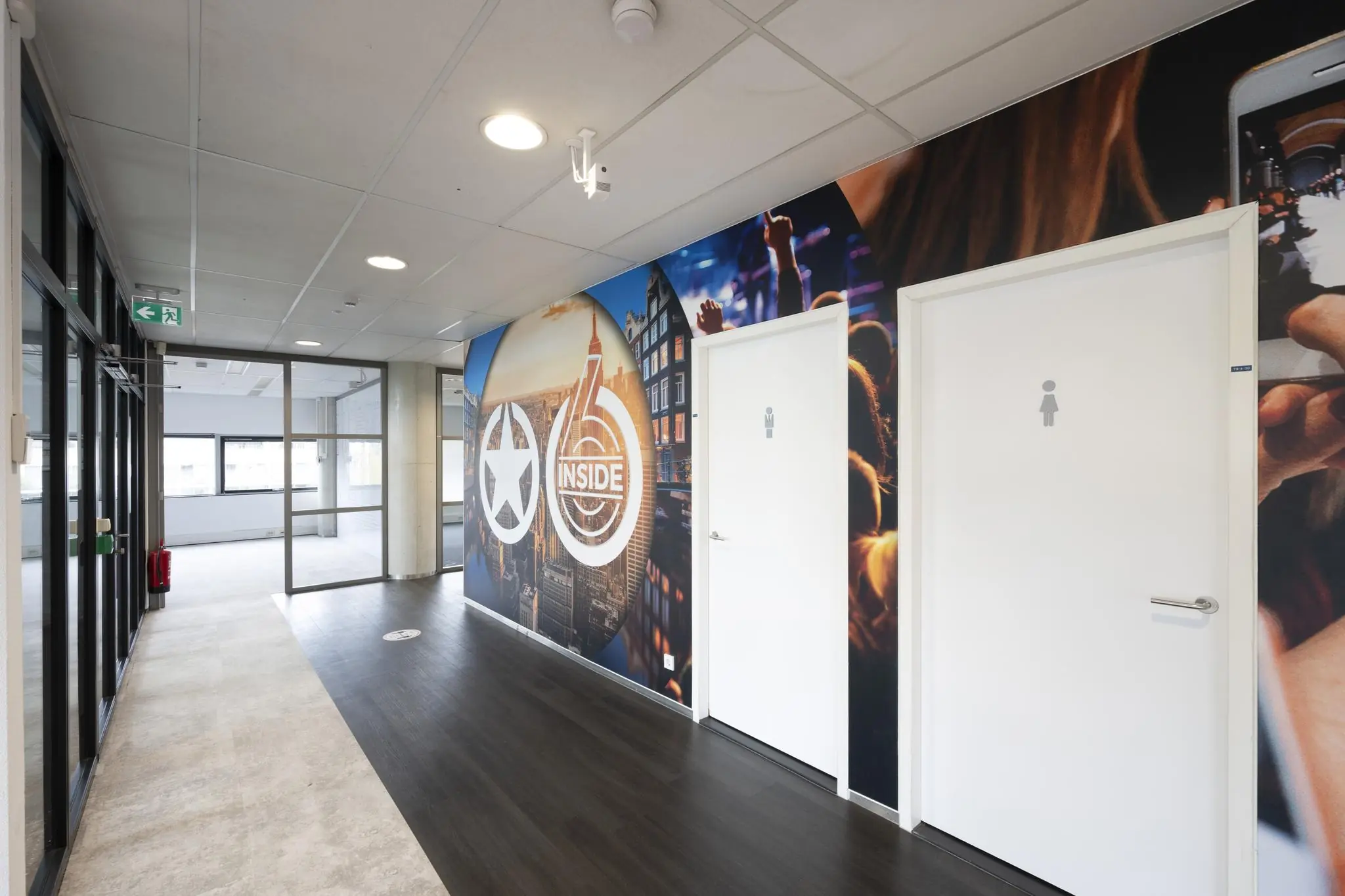 Gang in een modern kantoor met toiletten en een kleurrijke muur met het logo van 6 Inside op Rietlandpark.