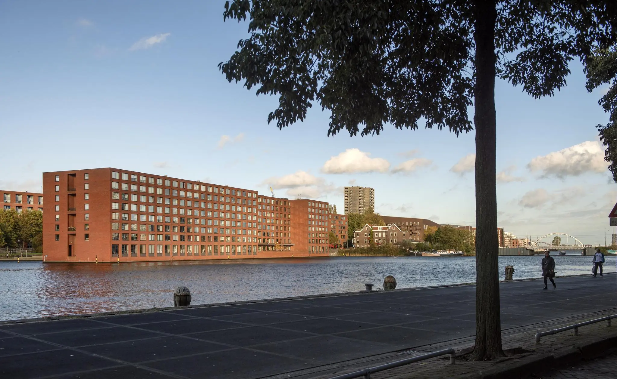 Uitzicht op het Rietlandpark met moderne bakstenen appartementsgebouwen langs het water in Amsterdam.