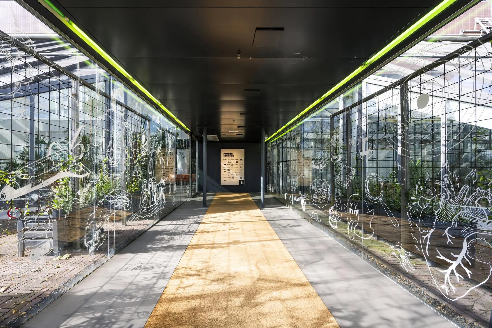 Glazen overdekte gang met witte illustraties op de ramen bij de Johan Huizingalaan in Amsterdam.