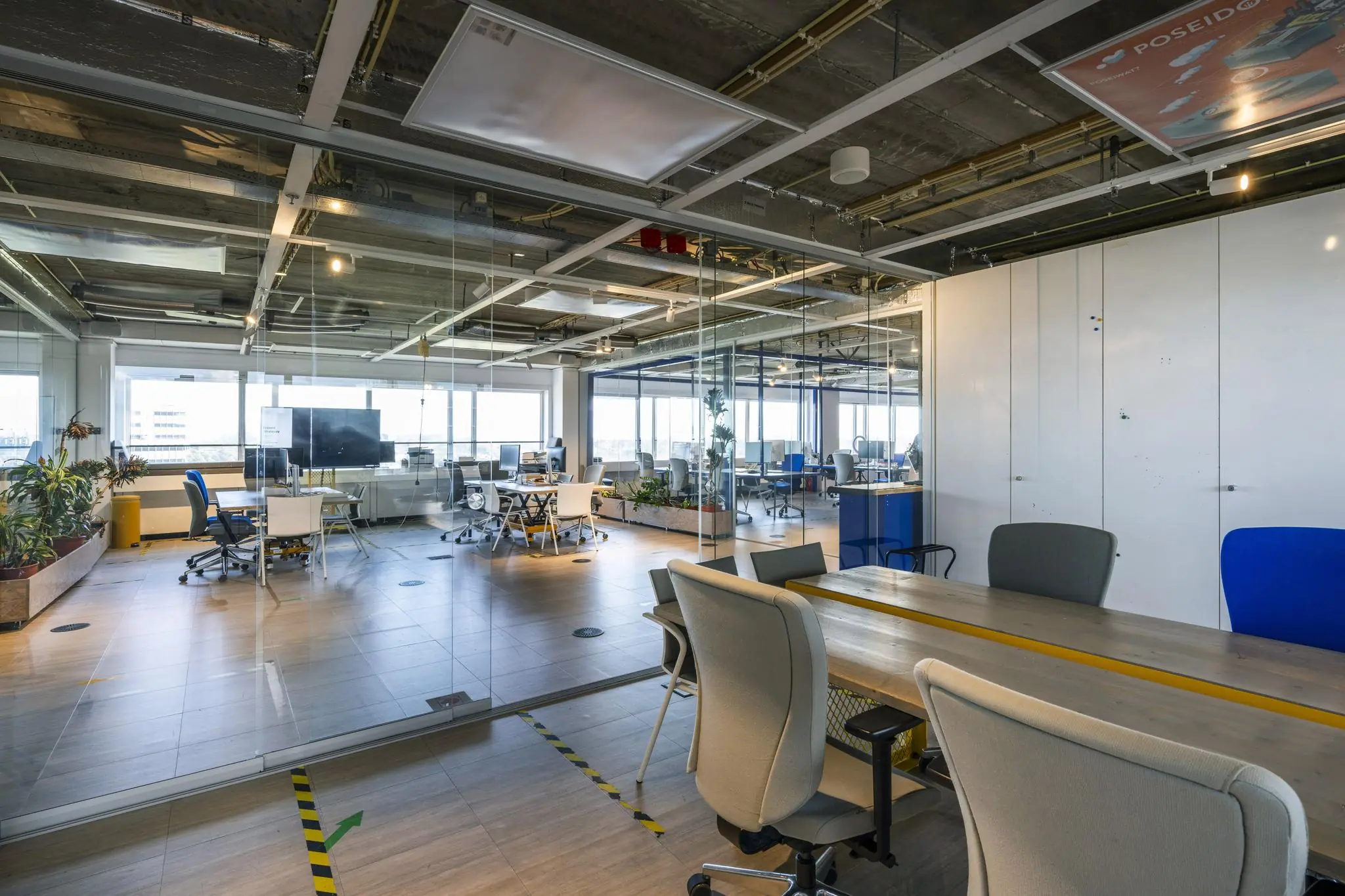 Moderne en open kantoorruimte aan de Johan Huizingalaan met glazen wanden, werkplekken en veel natuurlijk licht.