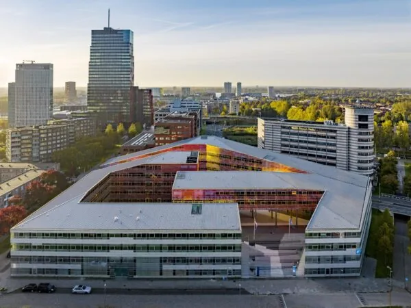 Luchtfoto van het moderne stadskantoor aan de W. Dreesweg in Almere met kleurrijke gevelaccenten.