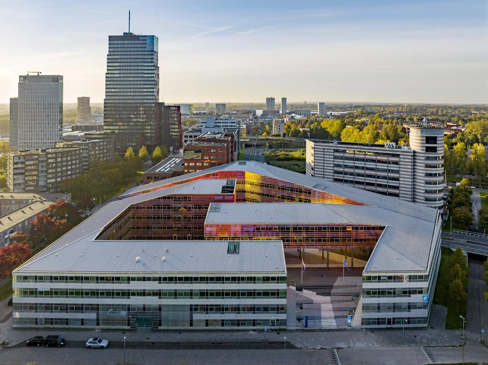 Luchtfoto van het moderne stadskantoor aan de W. Dreesweg in Almere met kleurrijke gevelaccenten.