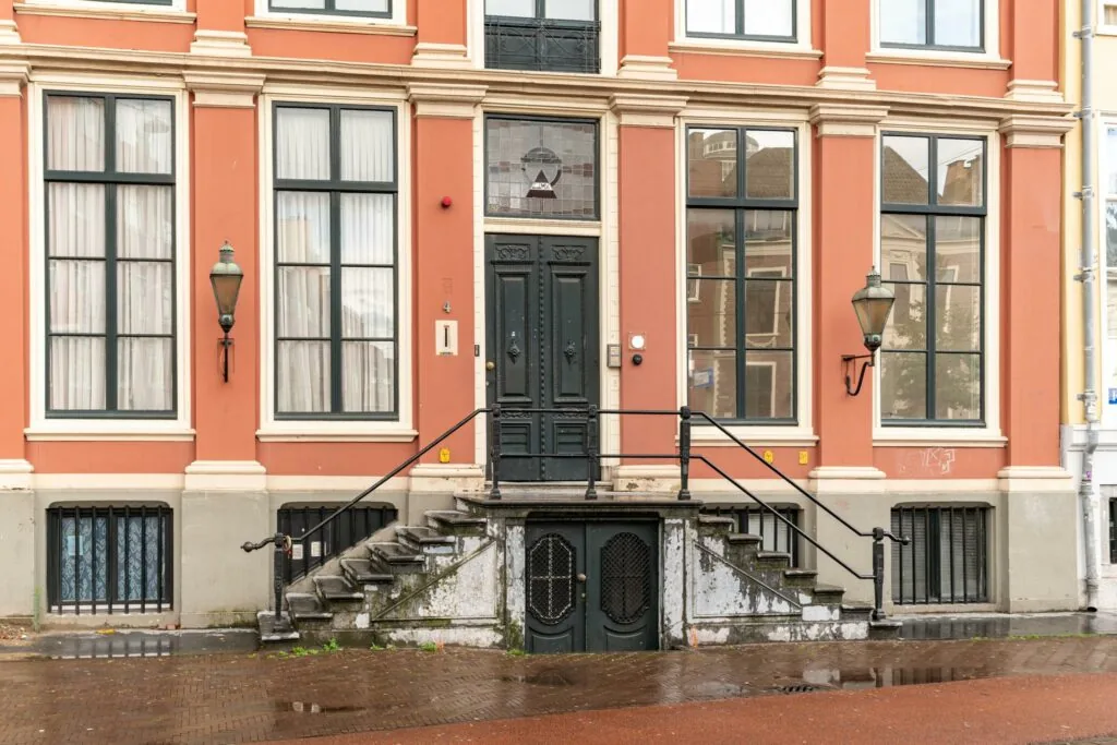 Voorgevel van een klassiek herenhuis aan de Prinsegracht met grote ramen, dubbele trap en zwarte voordeur.