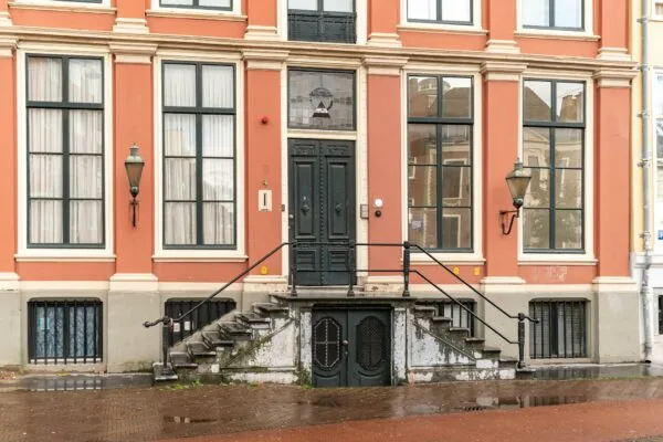 Voorgevel van een klassiek herenhuis aan de Prinsegracht met grote ramen, dubbele trap en zwarte voordeur.