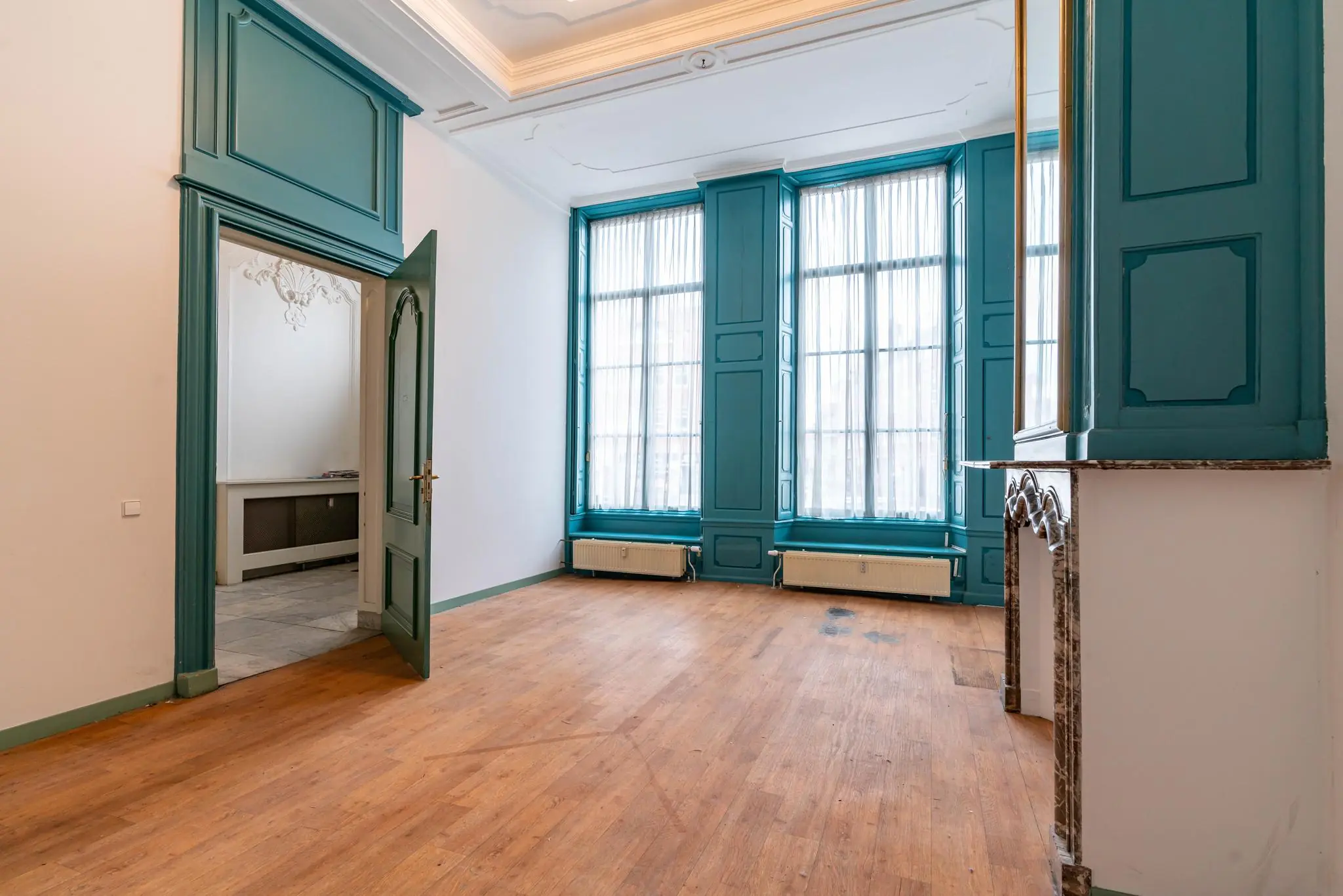 Leegstaand historisch vertrek aan de Prinsegracht met hoge ramen, houten vloer en klassieke details in blauwe tinten.
