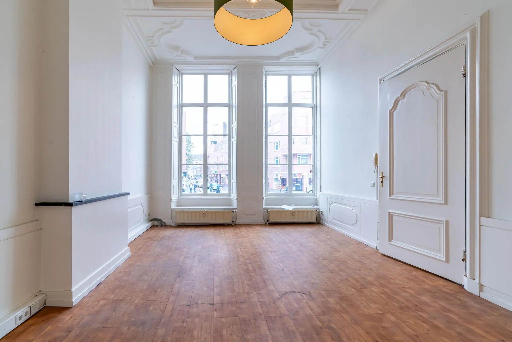 Lichte, hoge kamer met houten vloer en grote ramen aan de Prinsegracht.