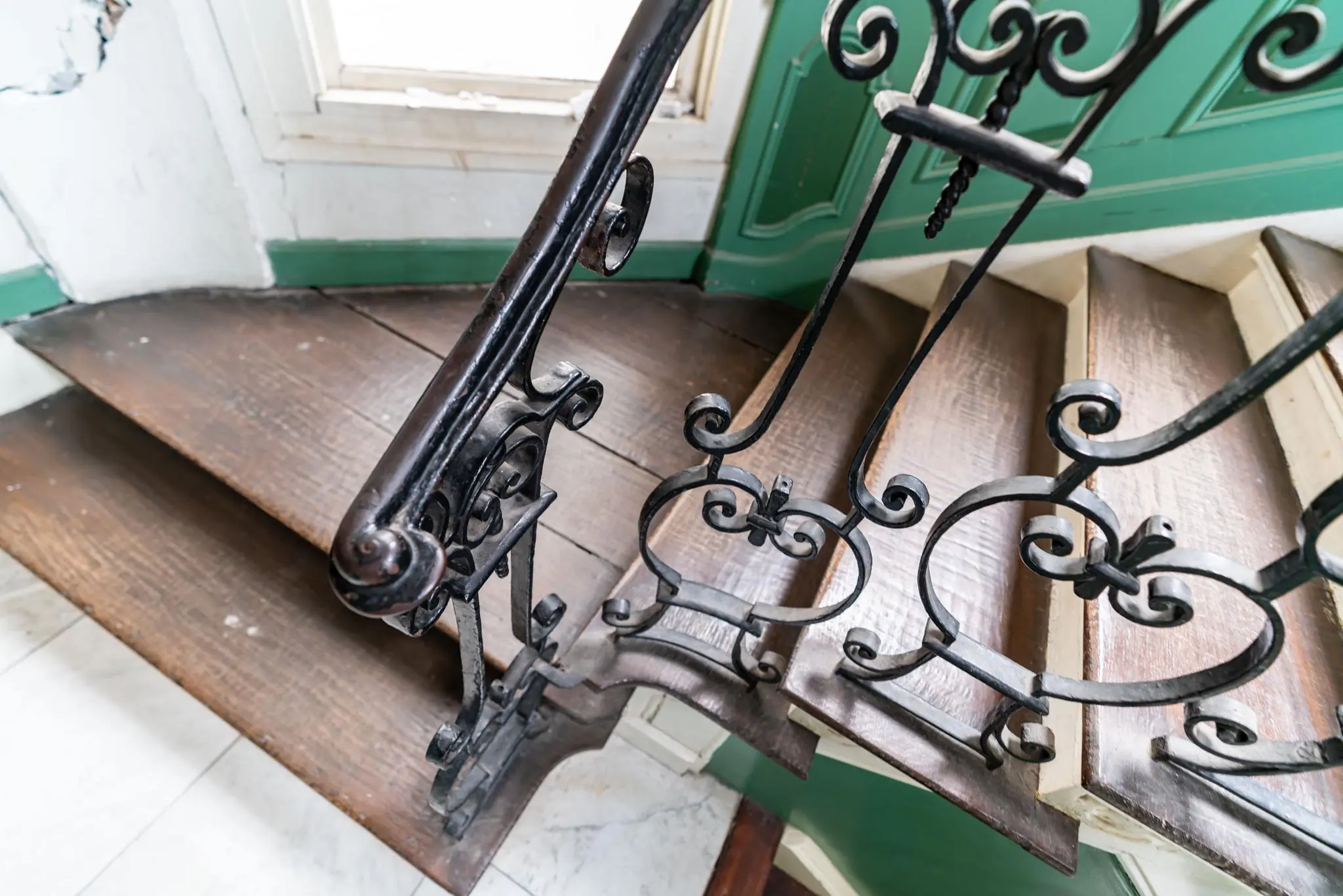 Houten trap met sierlijk smeedijzeren hekwerk in een historisch gebouw aan de Prinsegracht.