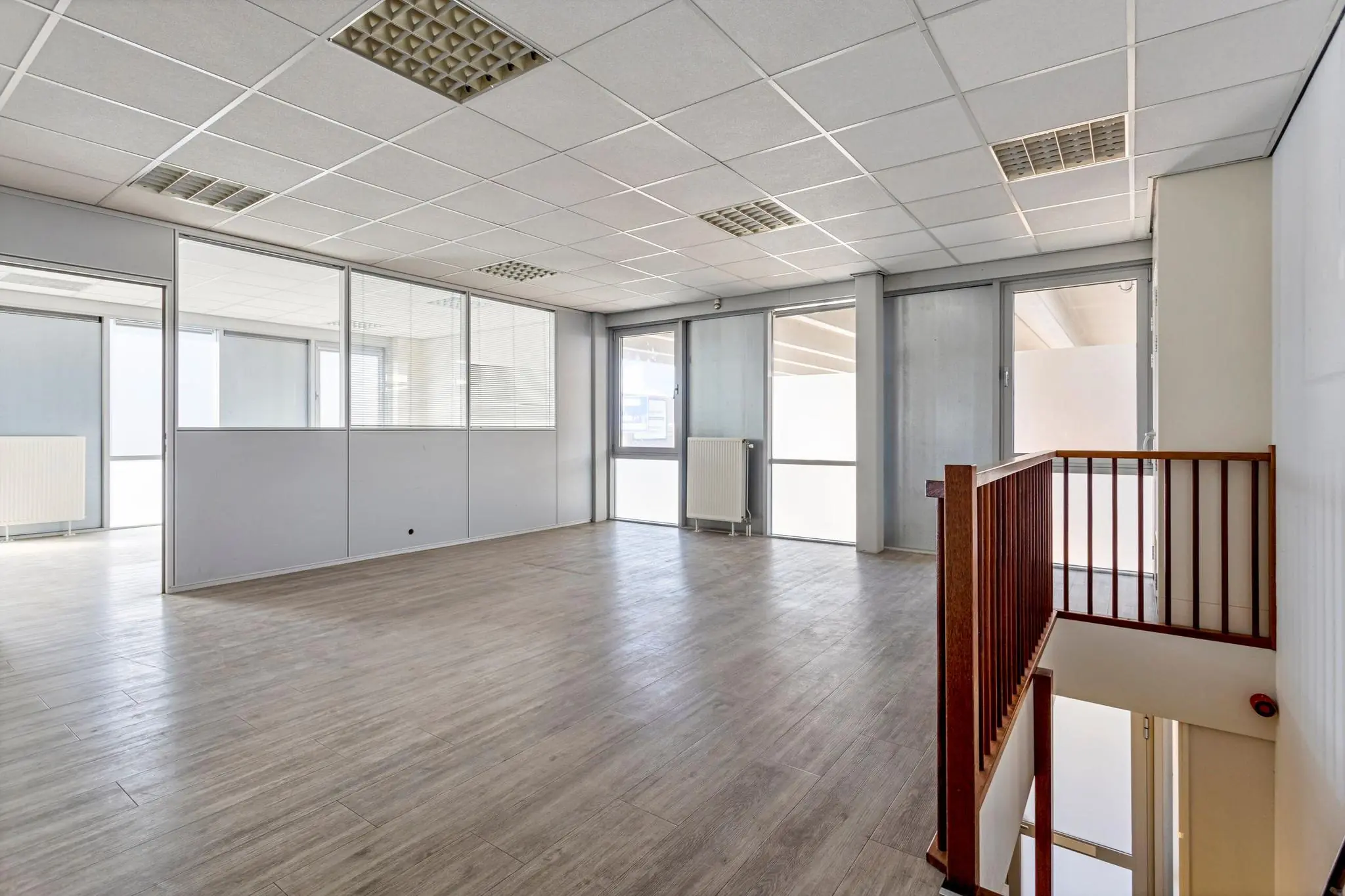 Lichte, lege kantoorruimte met glazen scheidingswanden en trap naar beneden aan de Tijnmuiden.
