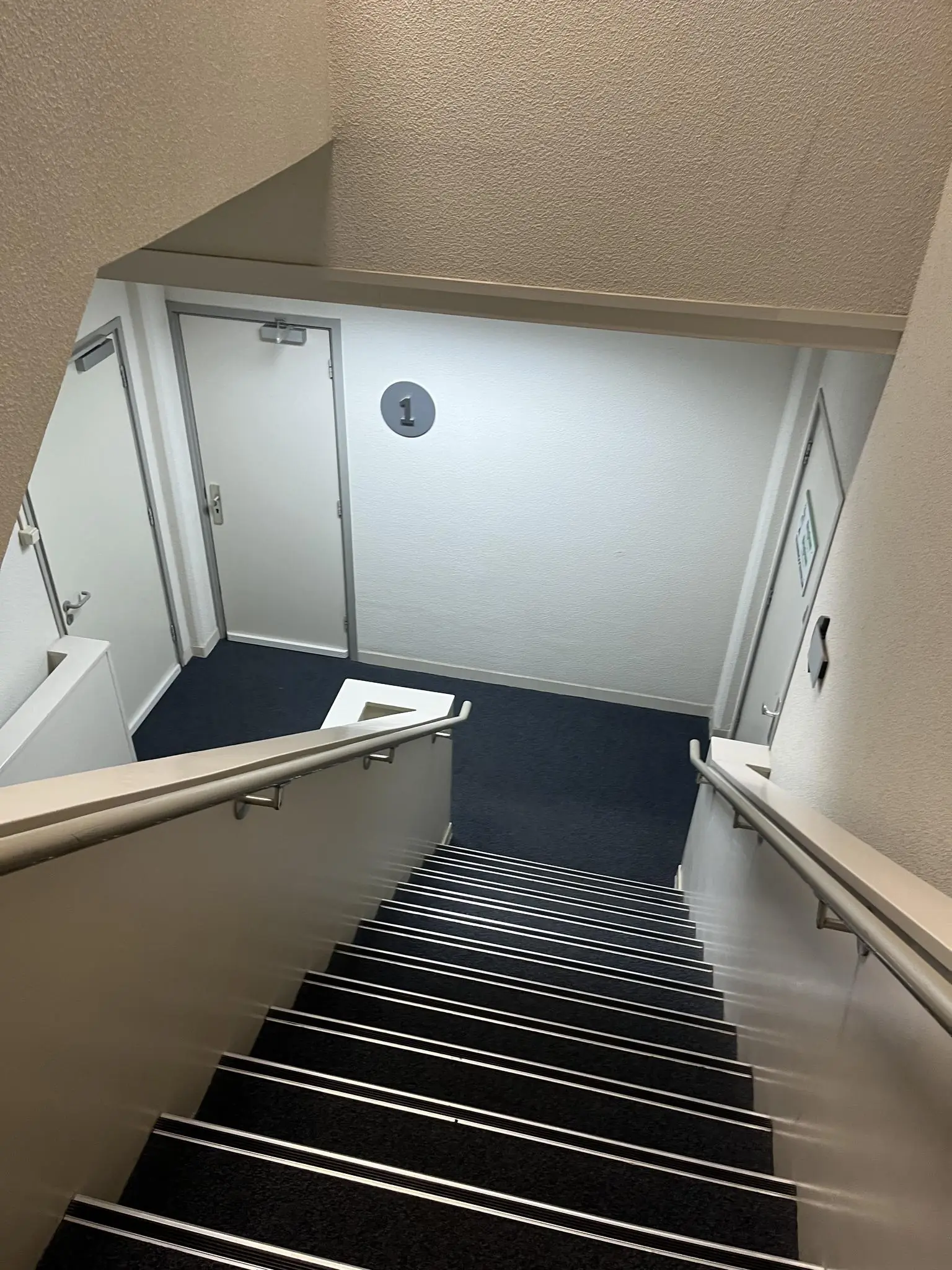 Trap van een trappenhuis in een gebouw aan de Hollantlaan, met zicht op de eerste verdieping.