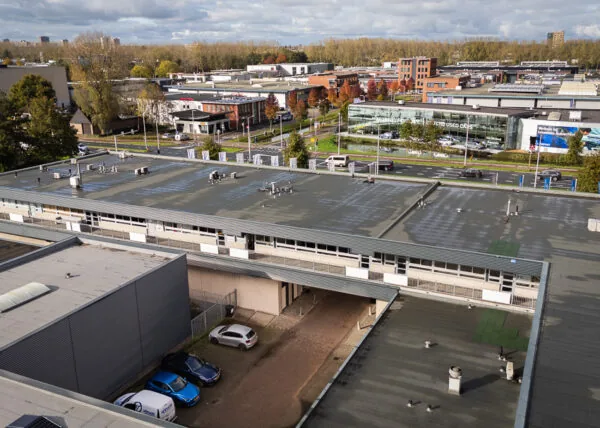 Luchtfoto van industrieterrein aan de Hoofdweg met kantoorgebouwen, parkeerplaatsen en autodealer.