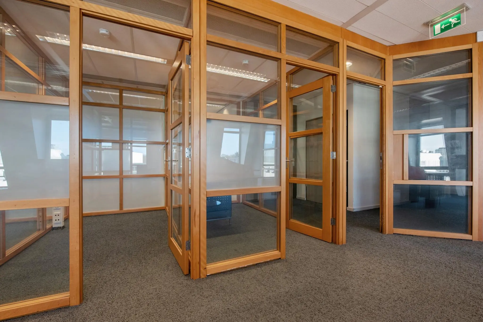 Kantoorruimte met glazen vergaderruimtes en houten kozijnen aan de Doelenstraat.