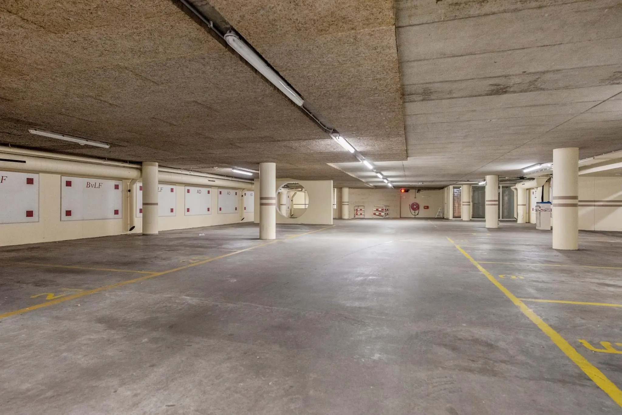 Ondergrondse parkeergarage aan de Doelenstraat met gemarkeerde parkeerplaatsen en betonnen pilaren.
