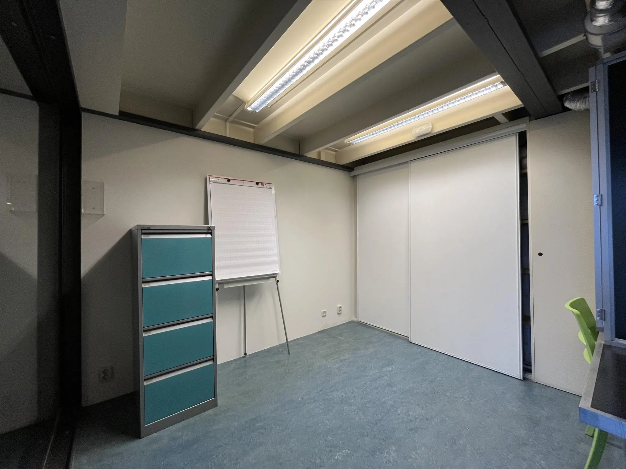 Kleine vergaderruimte aan de Kerkstraat met een flipover, ladekast en schuifdeurkast.