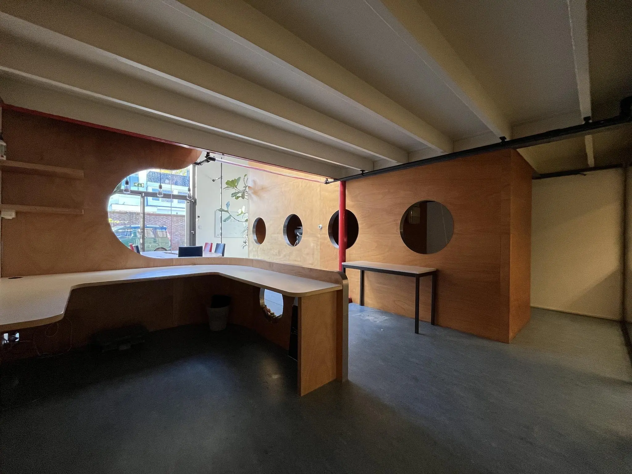 Modern ingerichte kantoorruimte aan de Kerkstraat met houten wanden en ronde ramen.