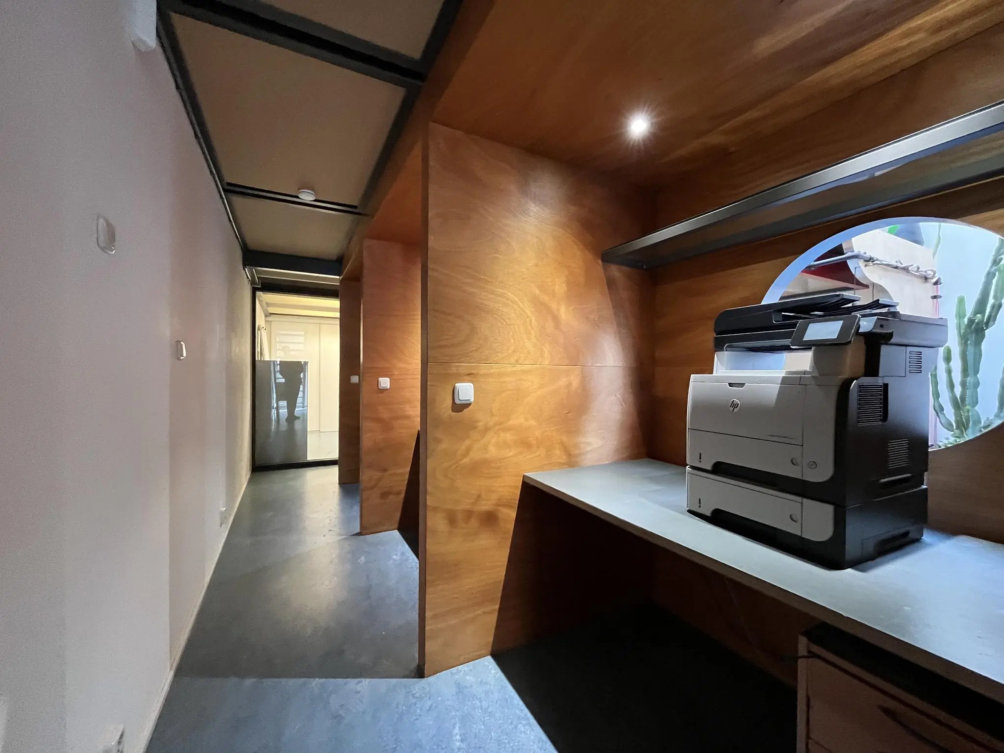 Printstation met een HP-printer in een houten nis aan de Kerkstraat, met zicht op een gang en ronde doorkijkopening.