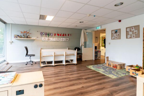 Speels ingerichte kinderopvangruimte met speelgoed, kindermeubels en knutselwerken aan de muur aan de Dedemsvaartweg.