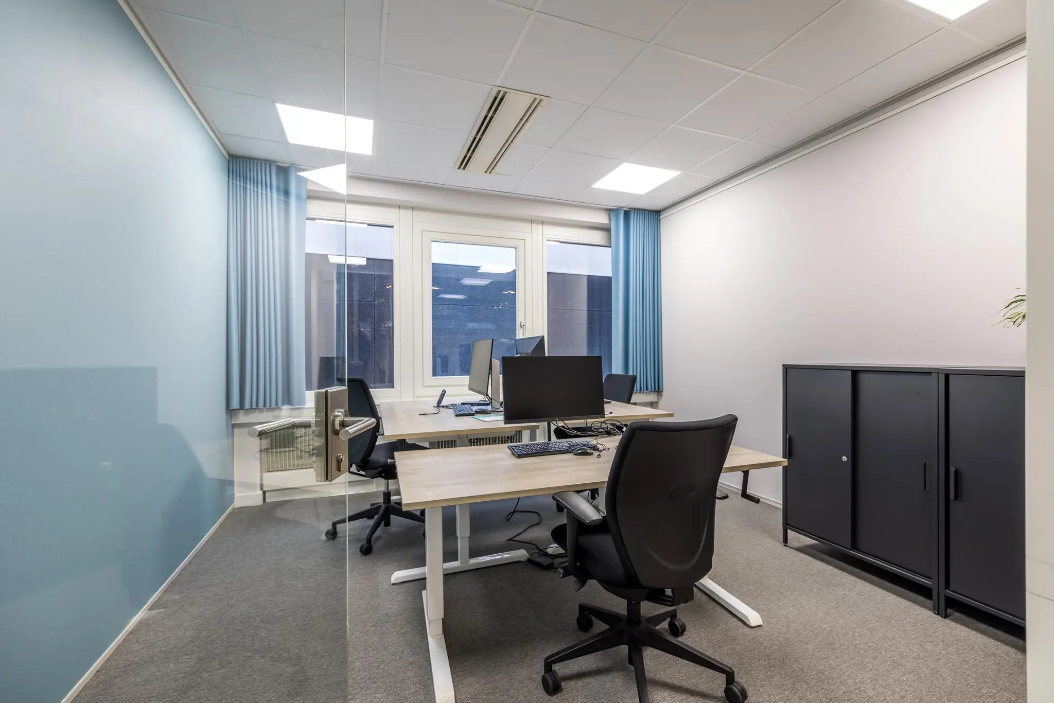 Moderne en nette kantoorruimte aan de Atoomweg met vier werkplekken, bureaus en computers.