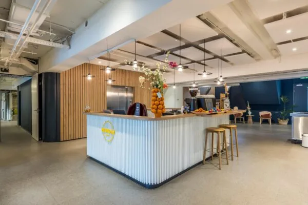 Moderne en sfeervol ingerichte ontvangstbalie van NewDay Offices aan de Atoomweg, met koffiecorner en zithoek.