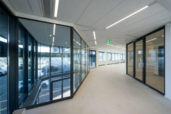 Licht en modern interieur van een kantoorpand aan de De Ruijterkade met grote ramen en glazen wanden.