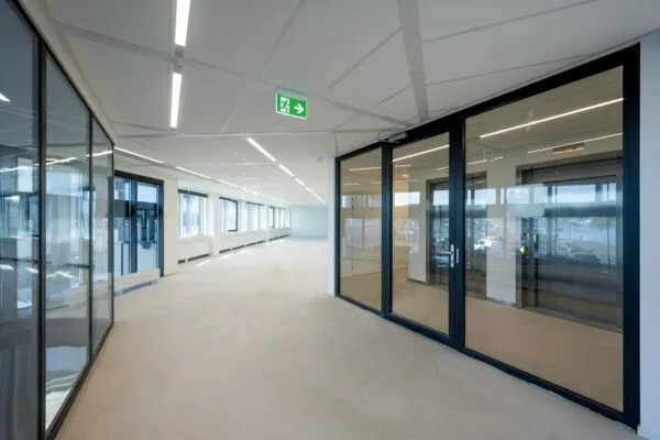 Lichte, moderne kantoorruimte aan de De Ruijterkade met glazen wanden en grote ramen.