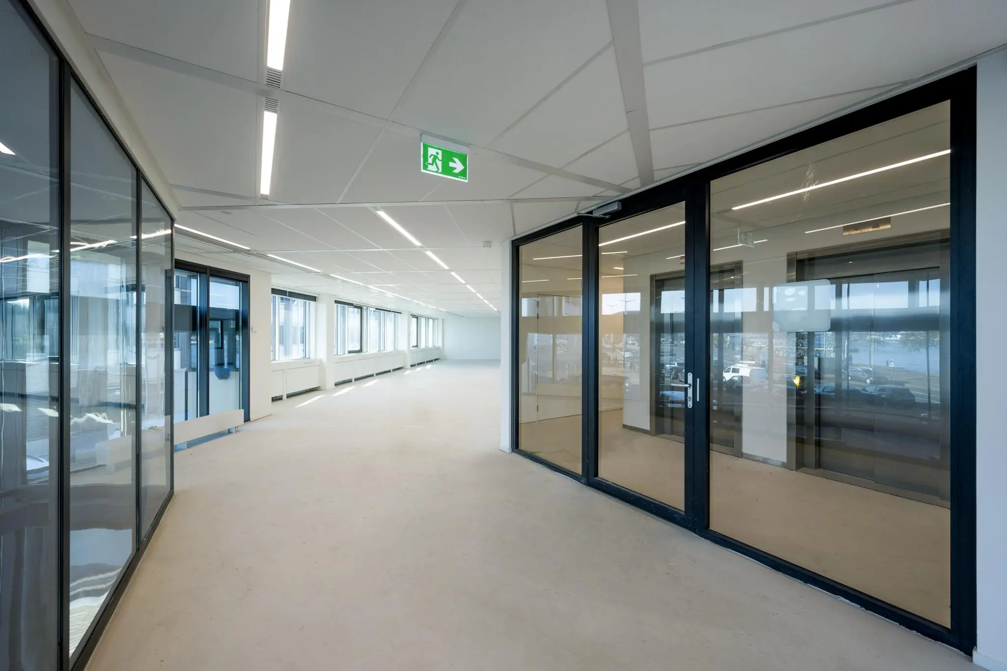 Lichte, moderne kantoorruimte aan de De Ruijterkade met glazen wanden en grote ramen.