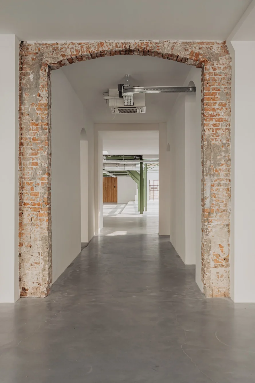 Gerenoveerde gang in een modern interieur aan de Plantage Middenlaan met zicht op een open ruimte en industriële elementen.