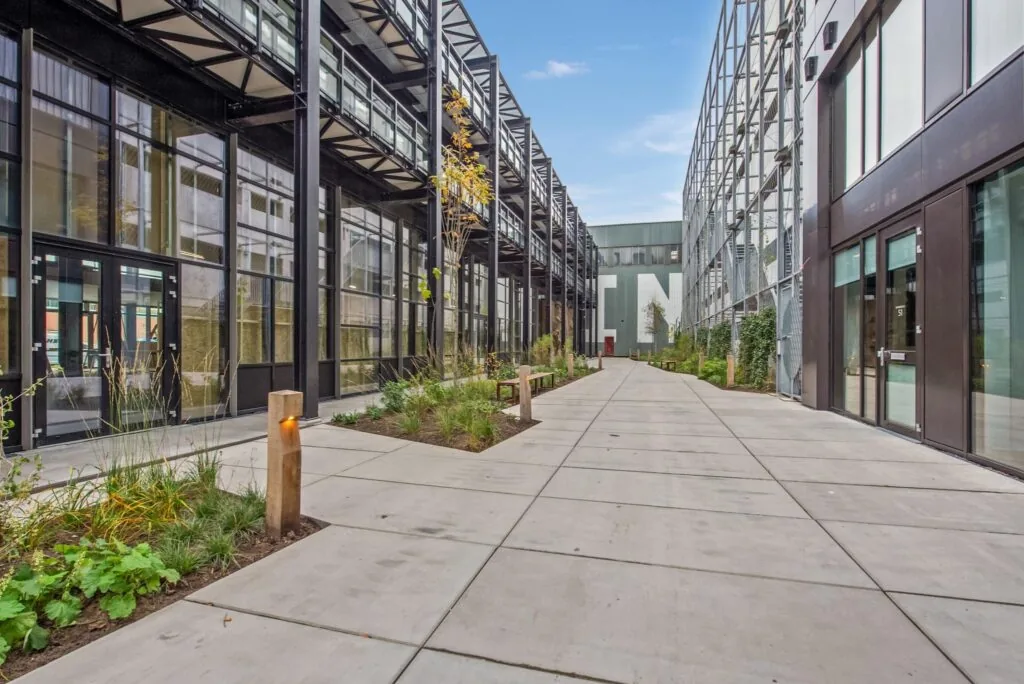 Modern binnenterrein aan de Saturnusstraat met glazen gevels, industriële architectuur en groenvoorziening.
