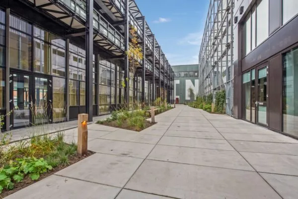 Modern binnenterrein aan de Saturnusstraat met glazen gevels, industriële architectuur en groenvoorziening.