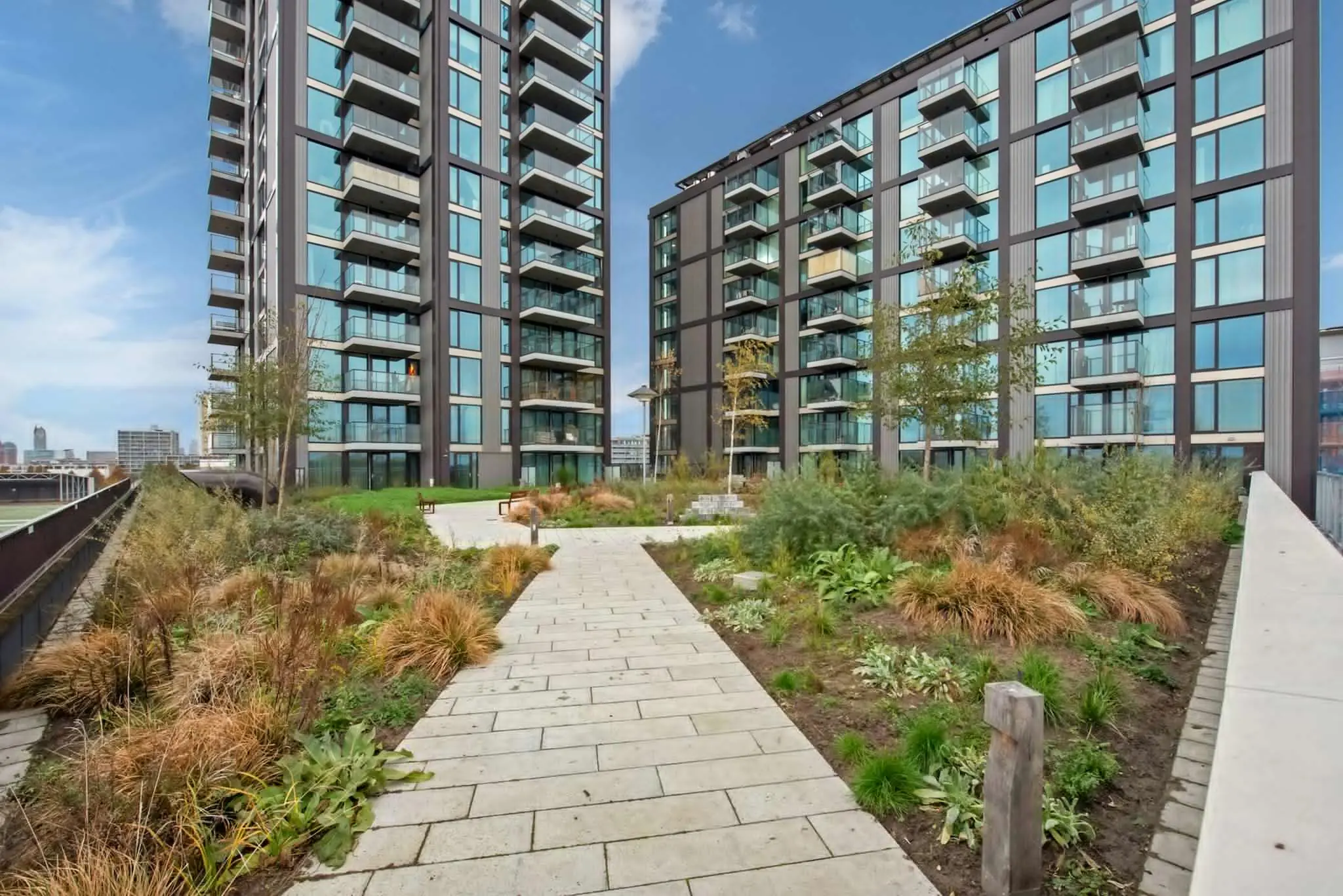 Moderne appartementencomplexen aan de Saturnusstraat met een groen aangelegde binnentuin en wandelpaden.