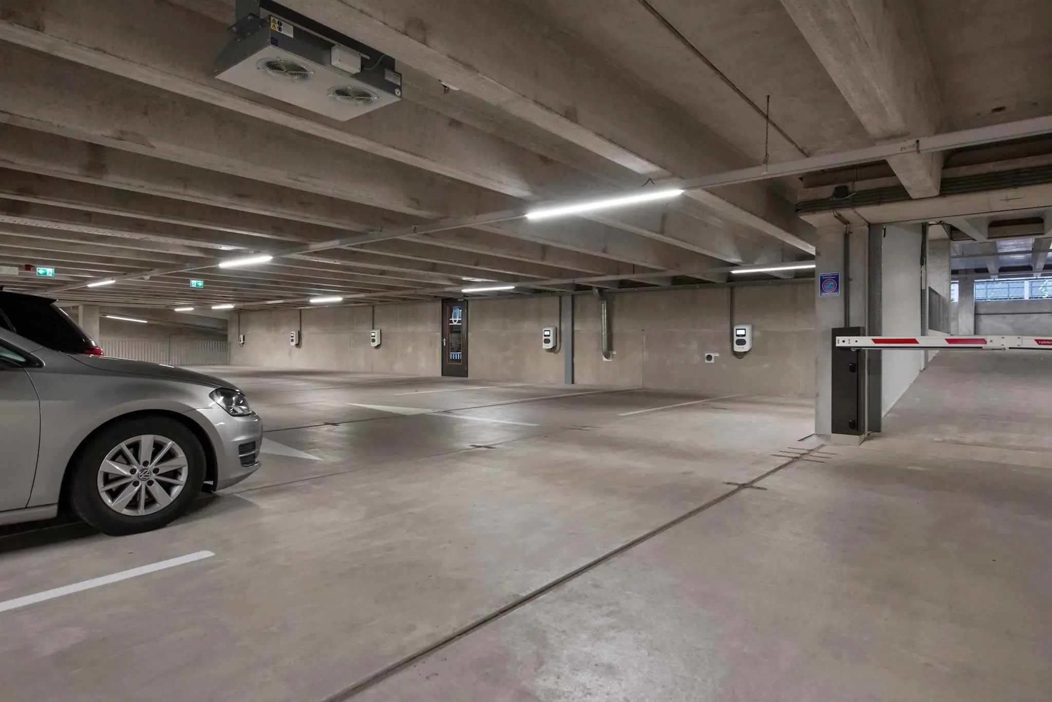 Ondergrondse parkeergarage aan de Saturnusstraat met oplaadpunten voor elektrische auto's en een slagboom bij de inrit.
