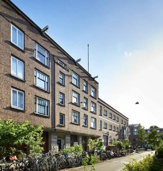 Bakstenen woongebouw aan de Ruysdaelkade in Amsterdam met fietsen geparkeerd langs de stoep.