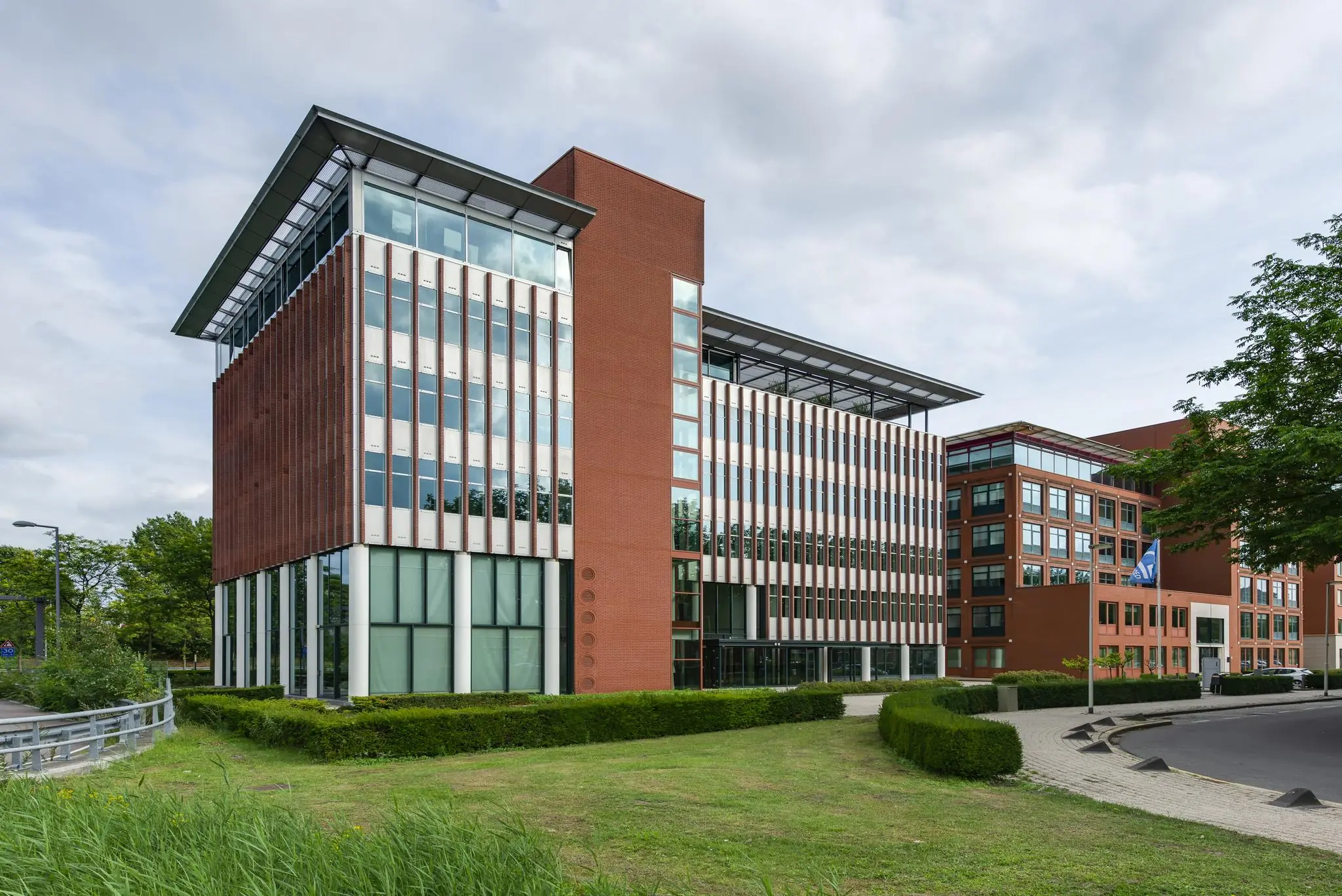 Modern kantoorgebouw aan de Lichtenauerlaan met roodbruine gevel en grote glaspartijen.