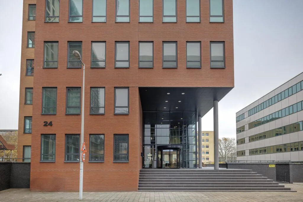 Ingang van een modern kantoorgebouw aan de Hiridostraat 3 met bakstenen gevel en glazen entree.