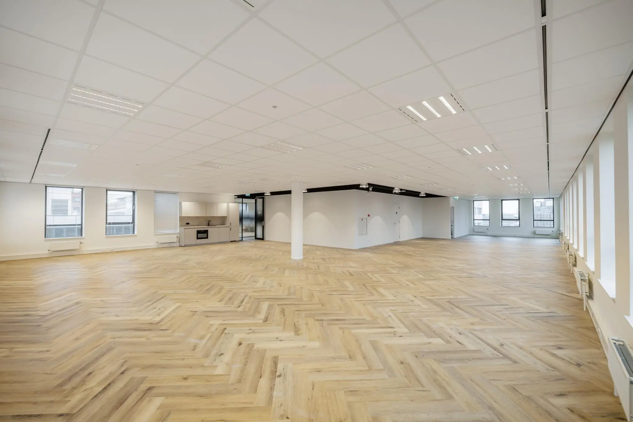 Ruime, lichte kantoorruimte aan de Hiridostraat met visgraatvloer, systeemplafond en open keuken.