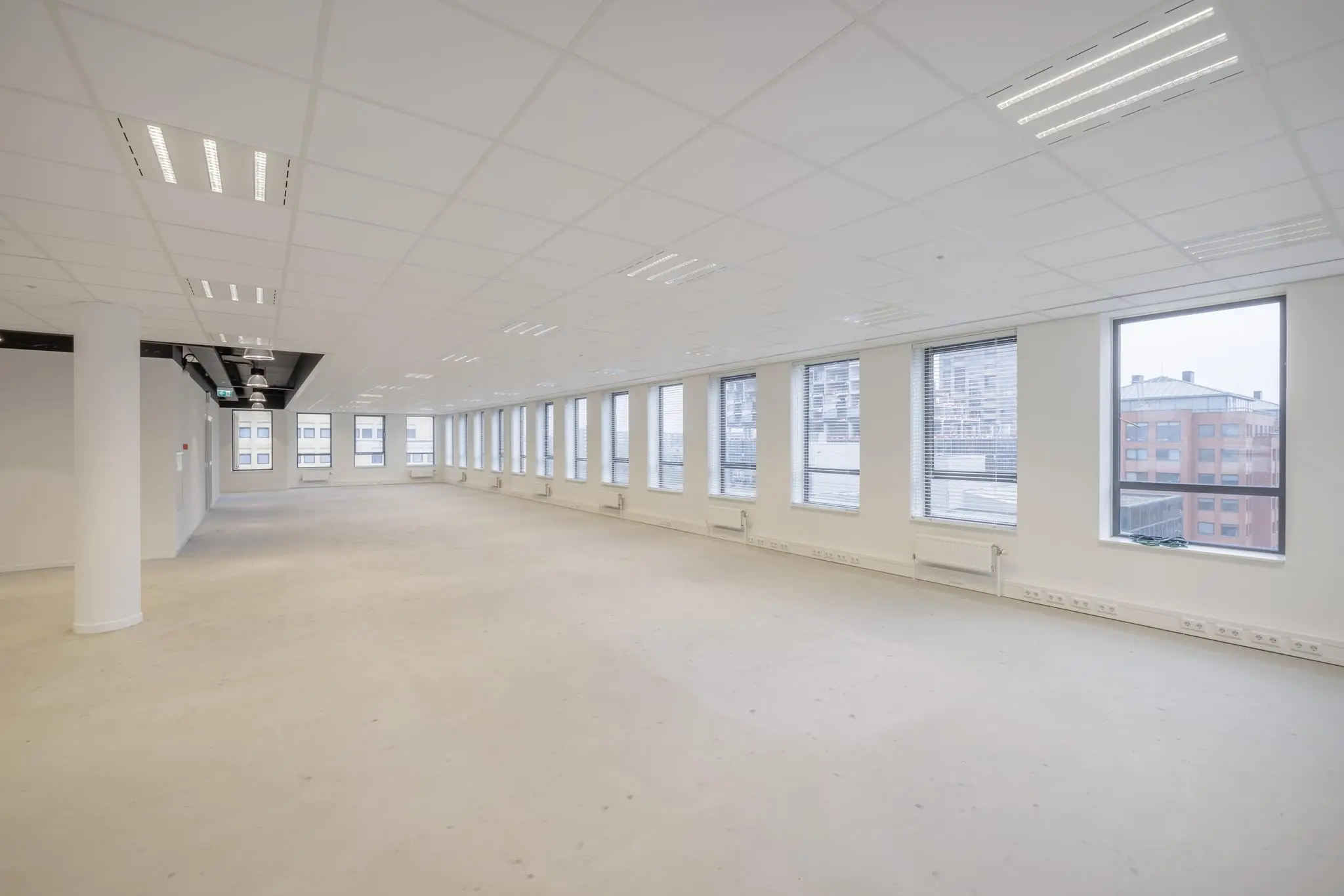 Licht en ruim leeg kantoorpand aan de Hiridostraat met grote ramen en systeemplafond.