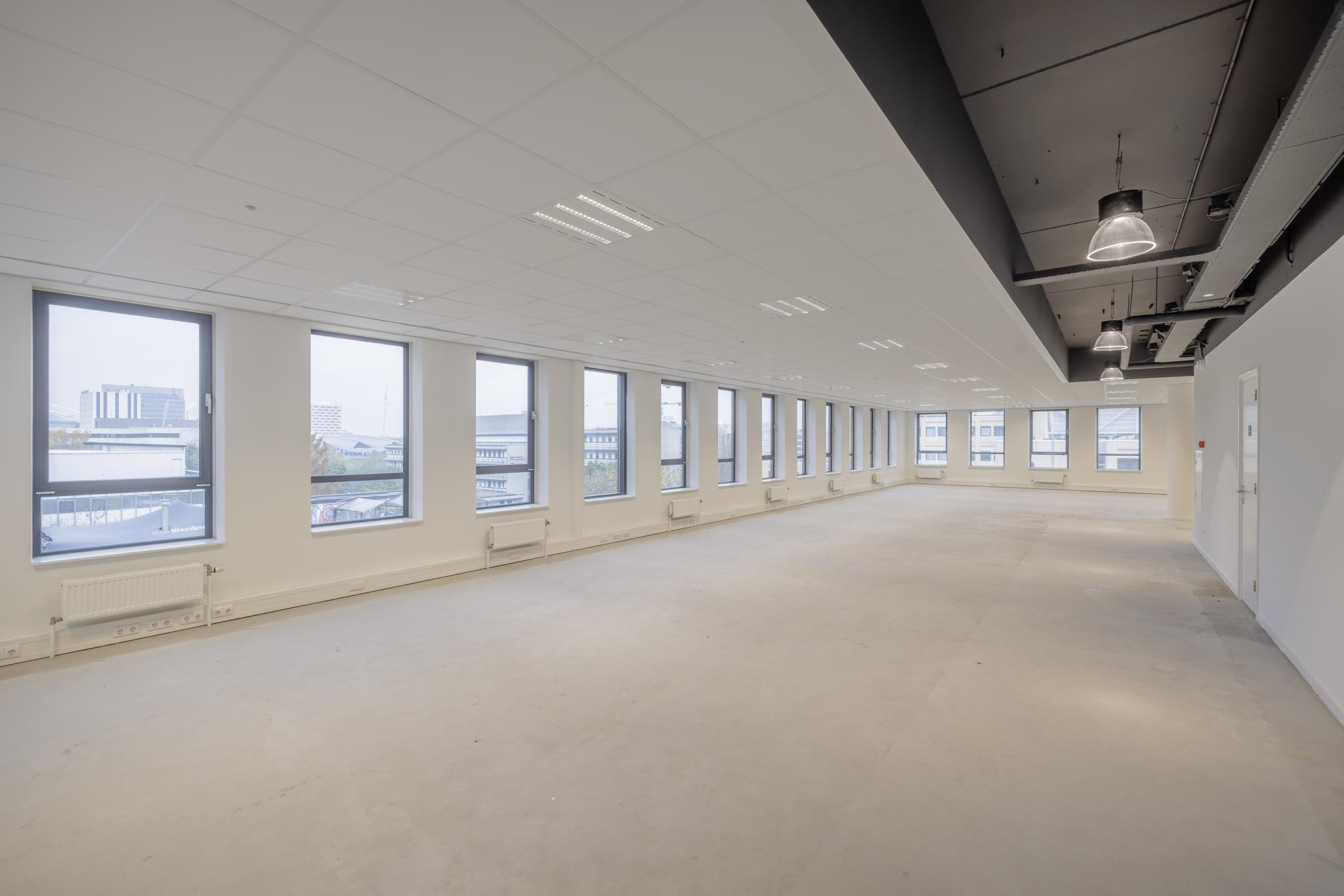 Leeg kantoorpand aan de Hiridostraat met grote ramen en systeemplafond.