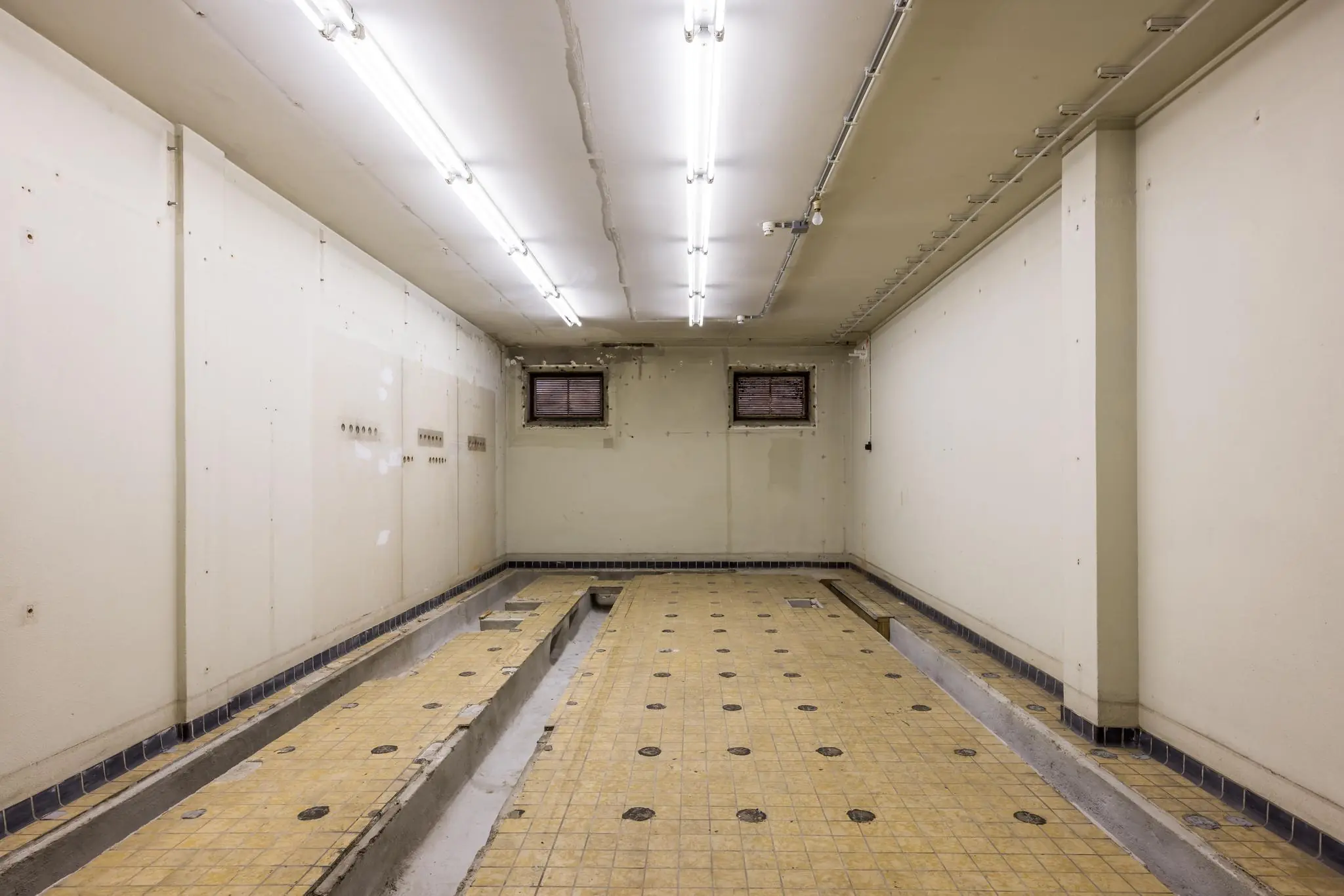 Lege, betegelde garage of onderhoudsruimte met smeerput aan de Rembrandtlaan.